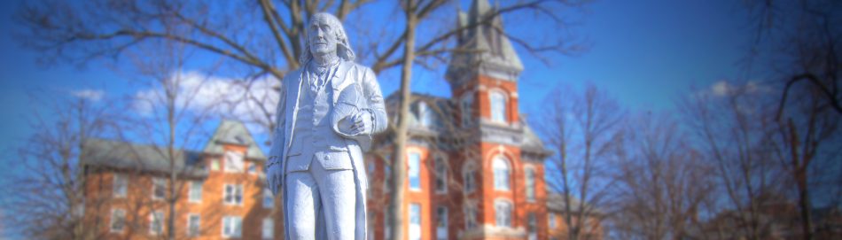 Photograph of the statue of Benjamin Franklin and Old Main at Franklin College