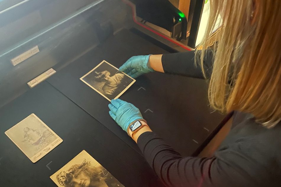 Photograph of a Franklin College student carefully handling a historical photo.