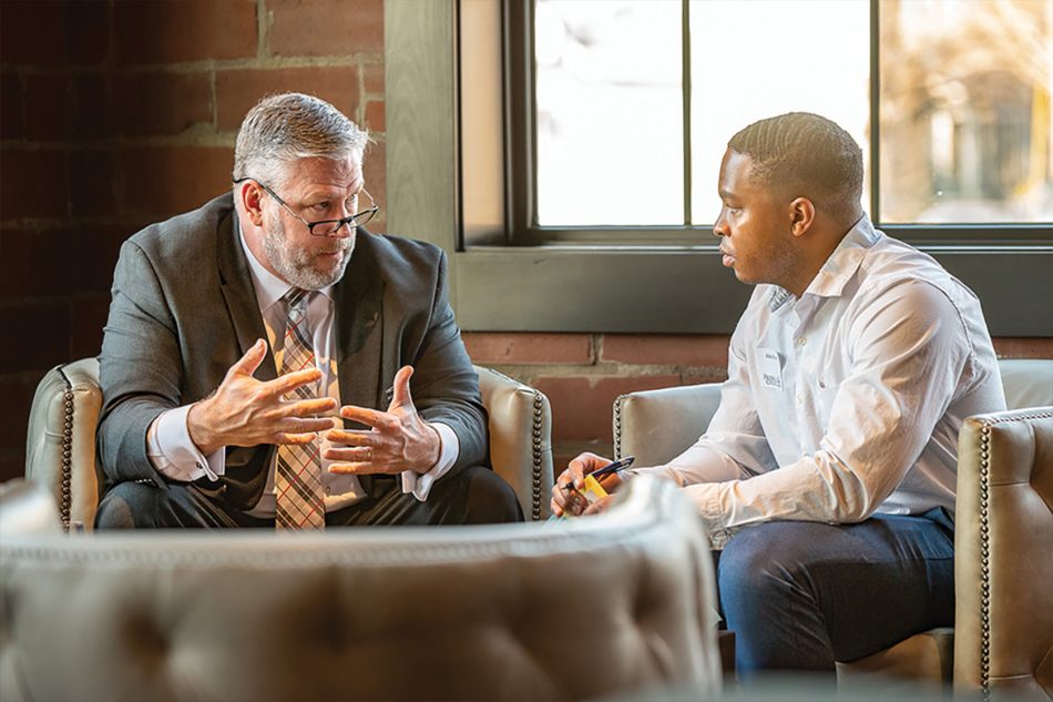 Photograph of two men talking during an alumni event sponsored by Franklin College.